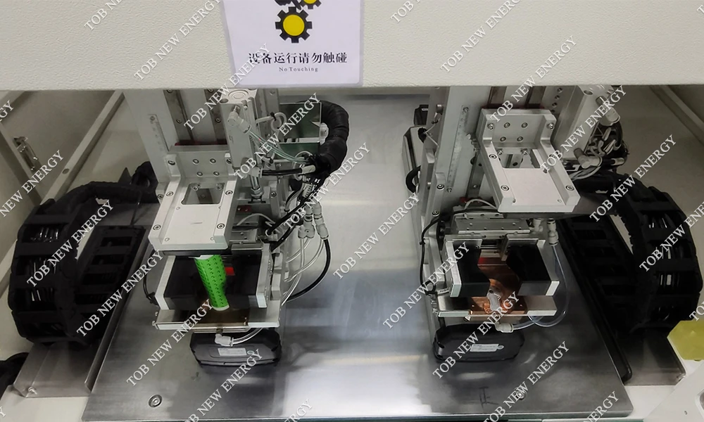 Commissioning a 32140 tabless cell collector-disc laser-welding machine, with the negative-electrode station on the left and positive-electrode station on the right